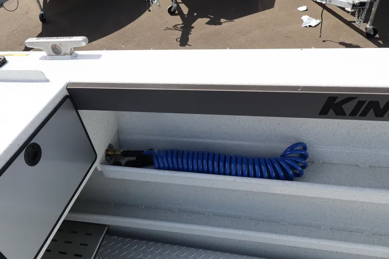 Slide: The Image of KingFisher 2425 Escape HT 2026 boat deck with coiled blue hose and storage compartment. - 11