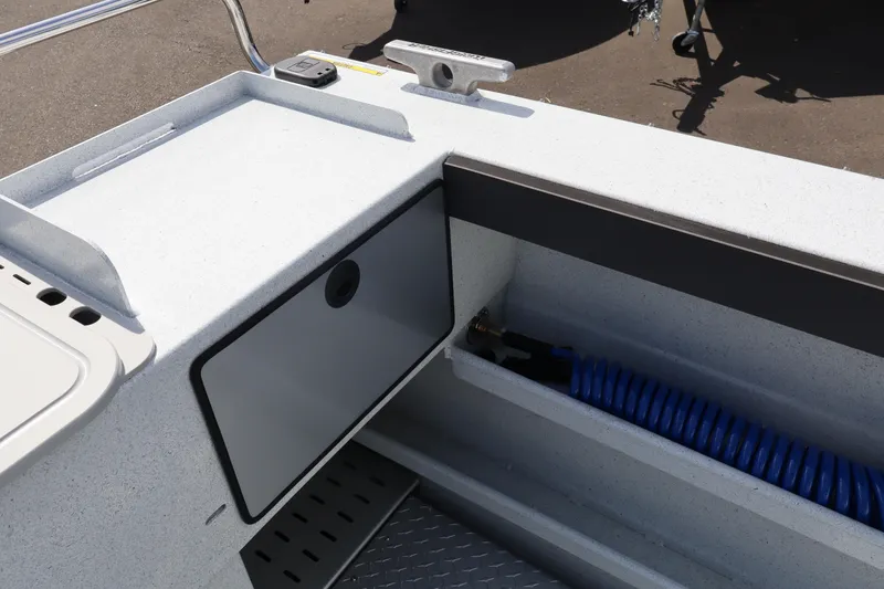 Slide: The Image of Interior view of 2026 KingFisher 2425 Escape HT boat, featuring storage compartment and coiled hose. - 12