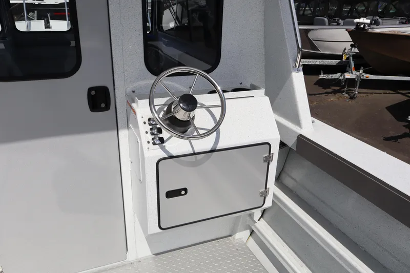Slide: The Image of 2026 KingFisher 2425 Escape HT boat helm with steering wheel and control panel. - 14