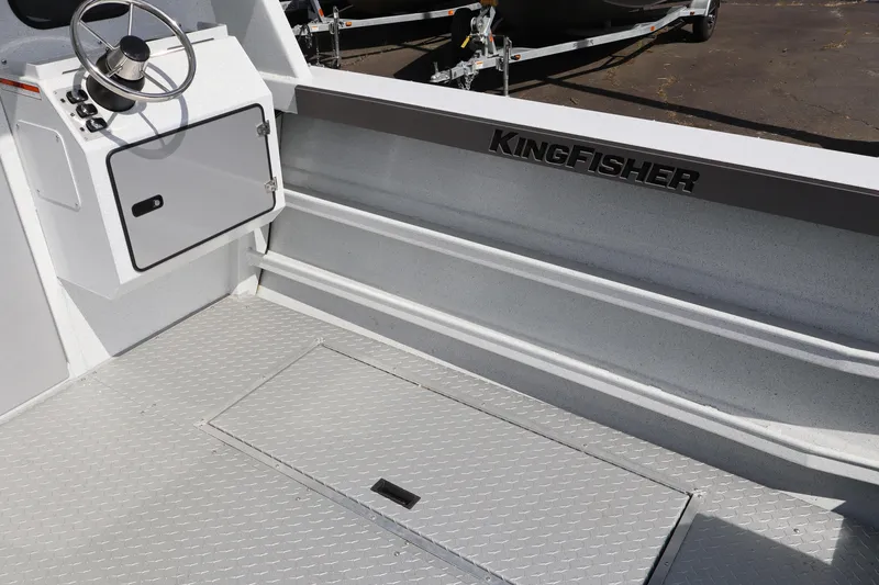 Slide: The Image of Interior of 2026 KingFisher 2425 Escape HT boat, featuring steering console and storage hatch. - 15