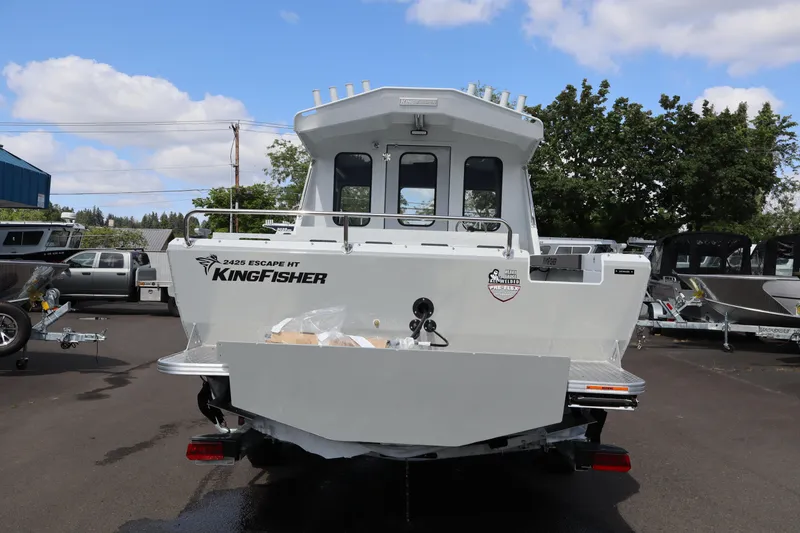 Slide: The Image of 2026 KingFisher 2425 Escape HT boat, rear view, parked outdoors under a blue sky. - 5