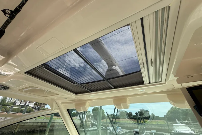 Slide: The Image of Interior view of 2021 Grady-White Express 370 boat with sunroof and scenic background. - 16