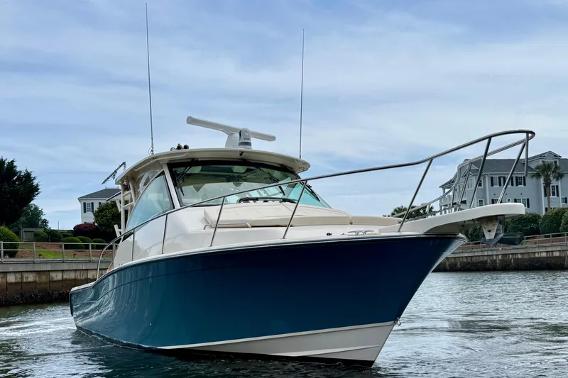 Slide: The Image of 2021 Grady-White Express 370 boat cruising near waterfront homes. - 2