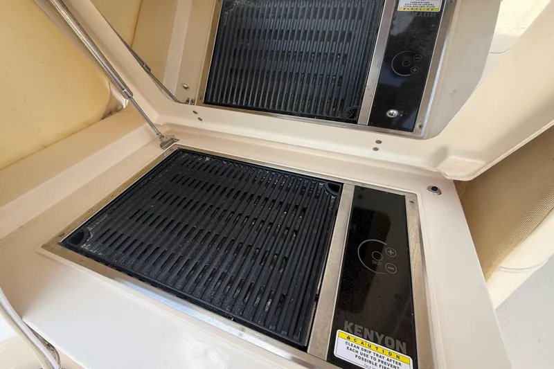 Slide: The Image of Built-in Kenyon grill on 2021 Grady-White Express 370 boat, featuring dual cooking surfaces. - 22