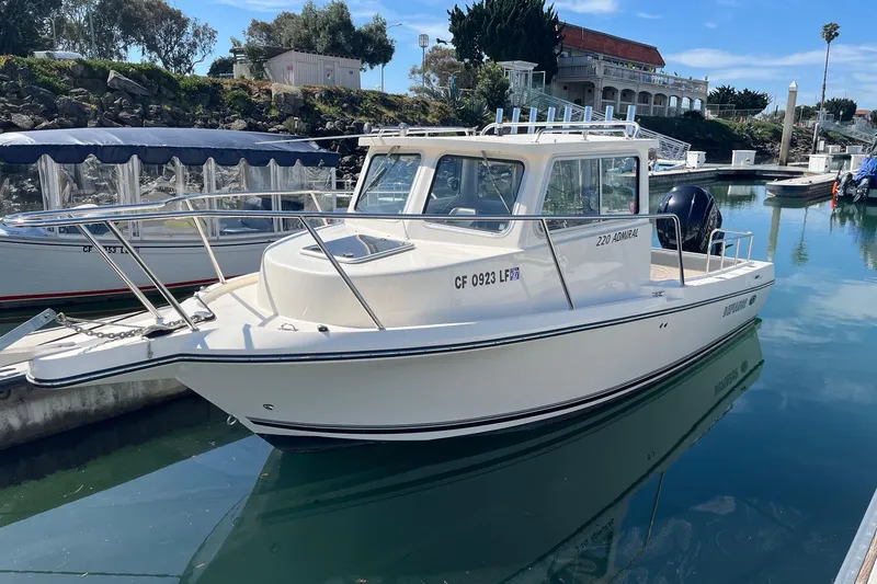The Image of 2023 Defiance Admiral 220 EX boat docked in a serene marina setting. - 0