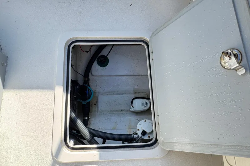 Slide: The Image of Open hatch of 2023 Defiance Admiral 220 EX boat, showing interior components and wiring. - 11