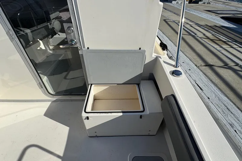 Slide: The Image of 2023 Defiance Admiral 220 EX boat interior with open storage compartment. - 12