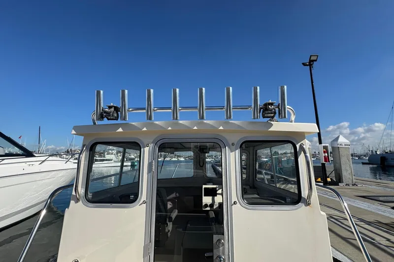Slide: The Image of 2023 Defiance Admiral 220 EX boat docked at marina under clear blue sky. - 13