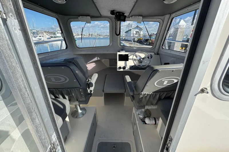 Slide: The Image of Interior of 2023 Defiance Admiral 220 EX boat with helm and seating. - 14