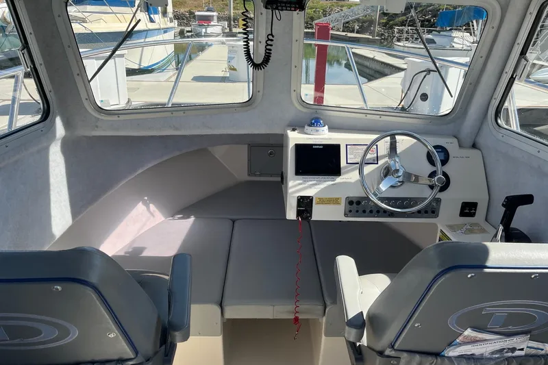 Slide: The Image of Interior of 2023 Defiance Admiral 220 EX boat, featuring steering wheel and control panel. - 15