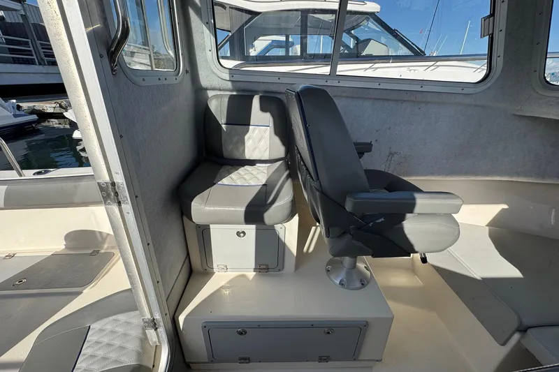 Slide: The Image of Interior of 2023 Defiance Admiral 220 EX boat with cushioned seating and storage. - 23