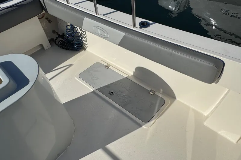 Slide: The Image of 2023 Defiance Admiral 220 EX boat interior with storage hatch and cushioned seating. - 7
