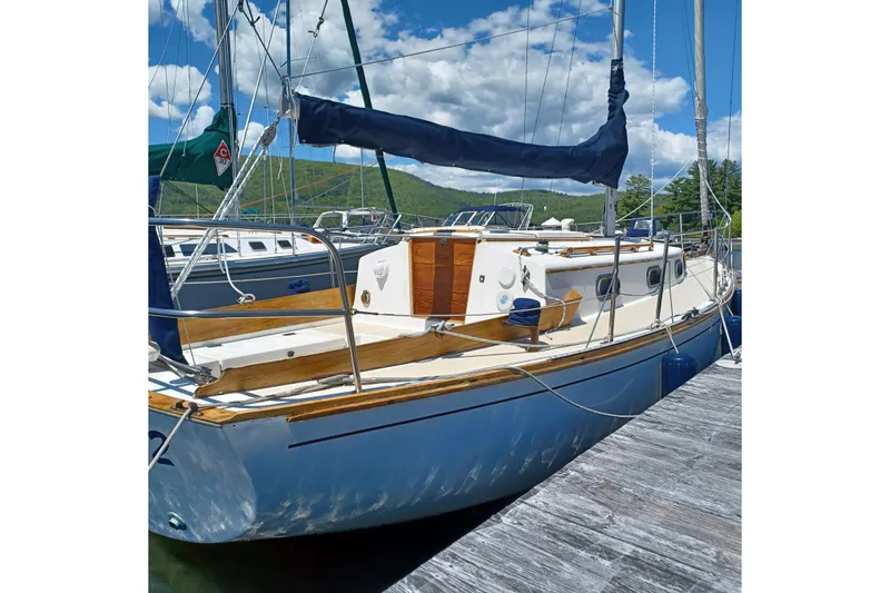 Slide: The Image of 1982 Cape Dory sailboat docked, featuring classic design and wooden accents under a clear sky. - 8