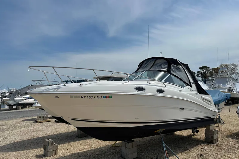 The Image of 2008 Sea Ray Sundancer 260 boat on dry dock, featuring sleek design and covered cockpit. - 0