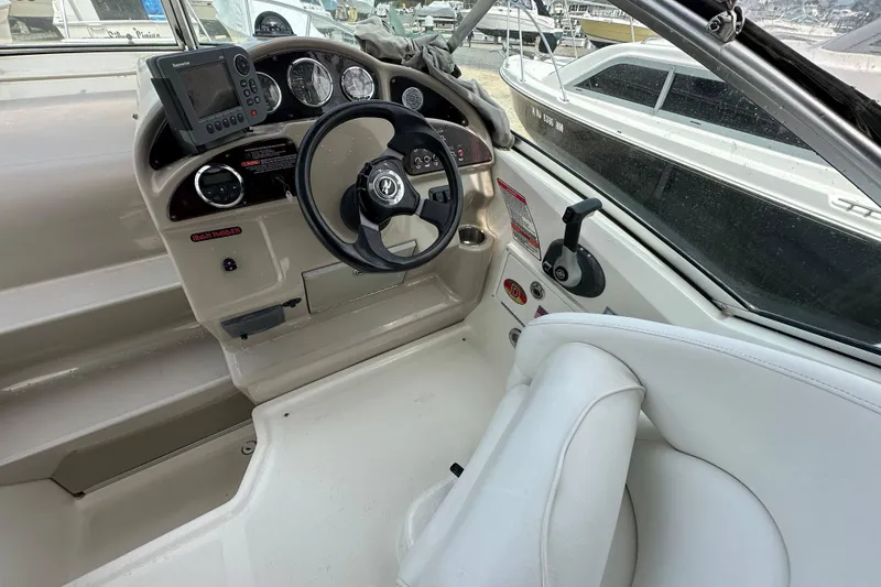 Slide: The Image of 2008 Sea Ray Sundancer 260 helm with steering wheel and navigation controls. - 11