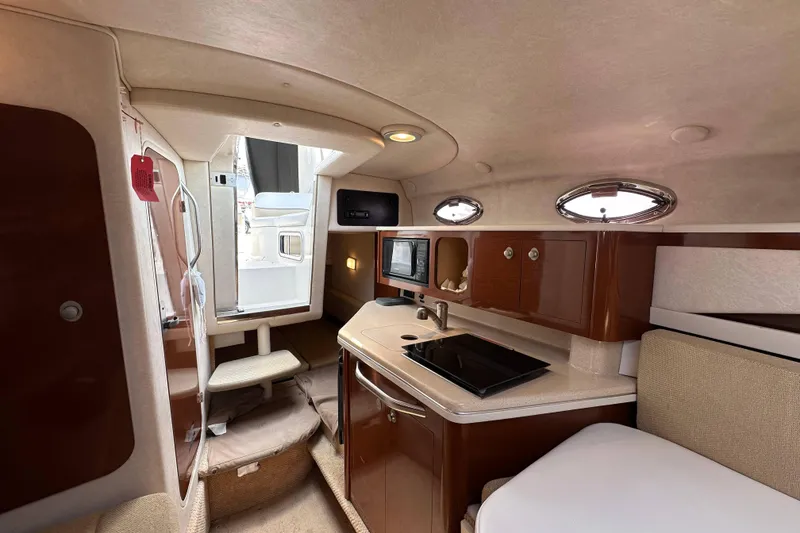 Slide: The Image of Interior of 2008 Sea Ray Sundancer 260, featuring a compact kitchen and seating area. - 17