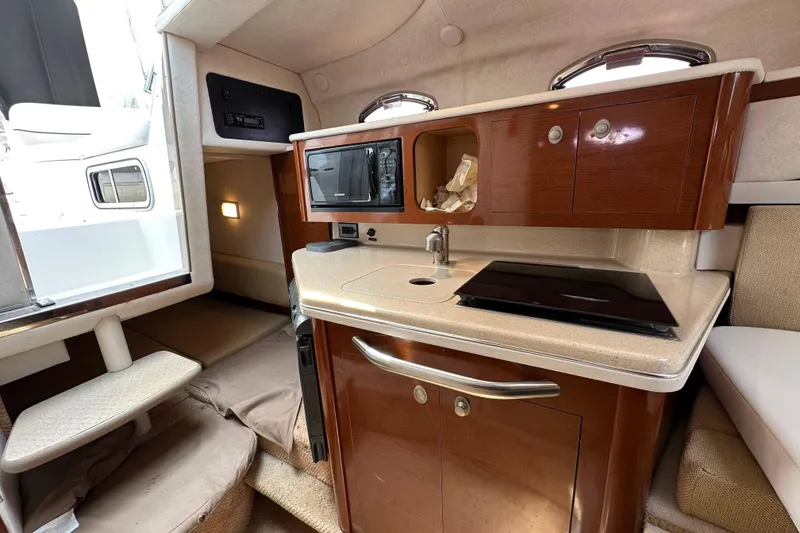 Slide: The Image of Interior of 2008 Sea Ray Sundancer 260 boat featuring kitchenette with microwave and sink. - 18