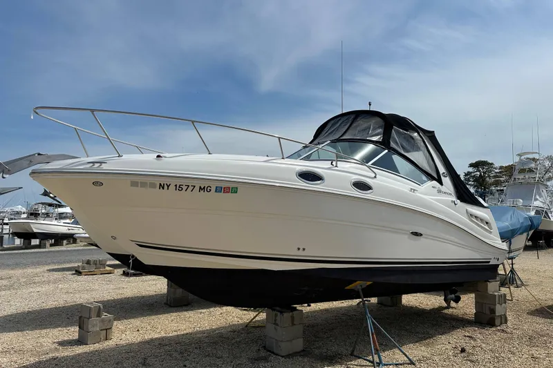 Slide: The Image of 2008 Sea Ray Sundancer 260 boat on dry dock, white hull, marina background. - 23