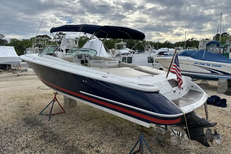 Slide: The Image of 2005 Chris-Craft Launch 28 boat on stands, with American flag, in a marina setting. - 10