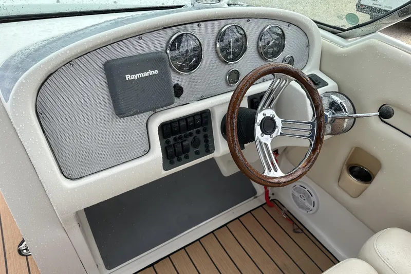 Slide: The Image of 2005 Chris-Craft Launch 28 dashboard with Raymarine equipment and wooden steering wheel. - 13