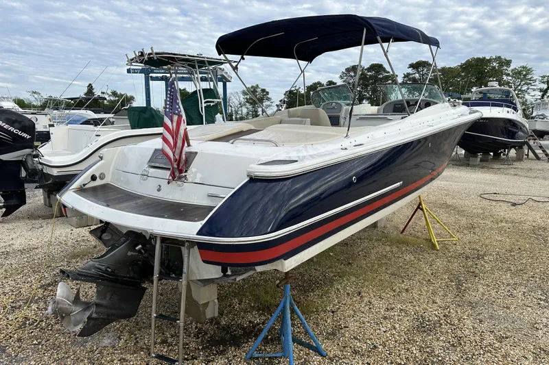 Slide: The Image of 2005 Chris-Craft Launch 28 boat with canopy, displayed on stands in a marina. - 2
