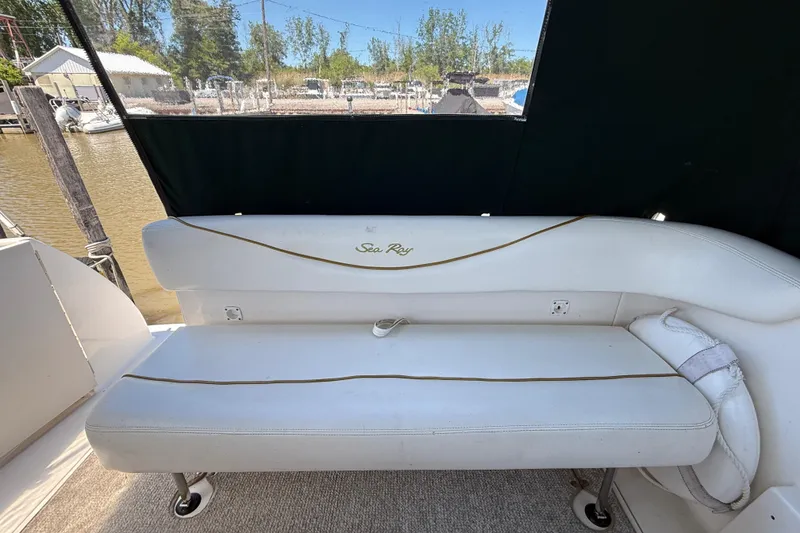 Slide: The Image of 2002 Sea Ray Sundancer 260 boat interior with white seating and outdoor view. - 12