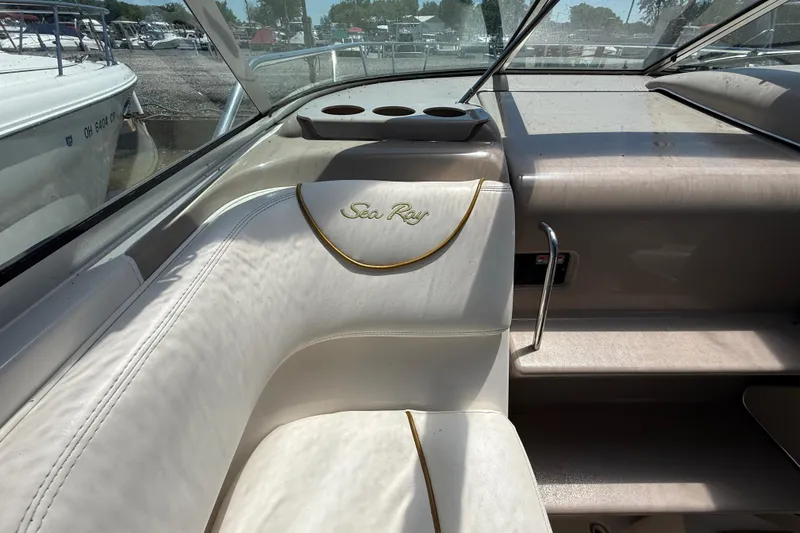 Slide: The Image of Interior of a 2002 Sea Ray Sundancer 260 boat, featuring white seating and cup holders. - 15