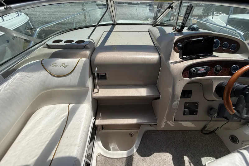 Slide: The Image of Interior view of a 2002 Sea Ray Sundancer 260 boat cockpit with steering wheel and seating. - 16