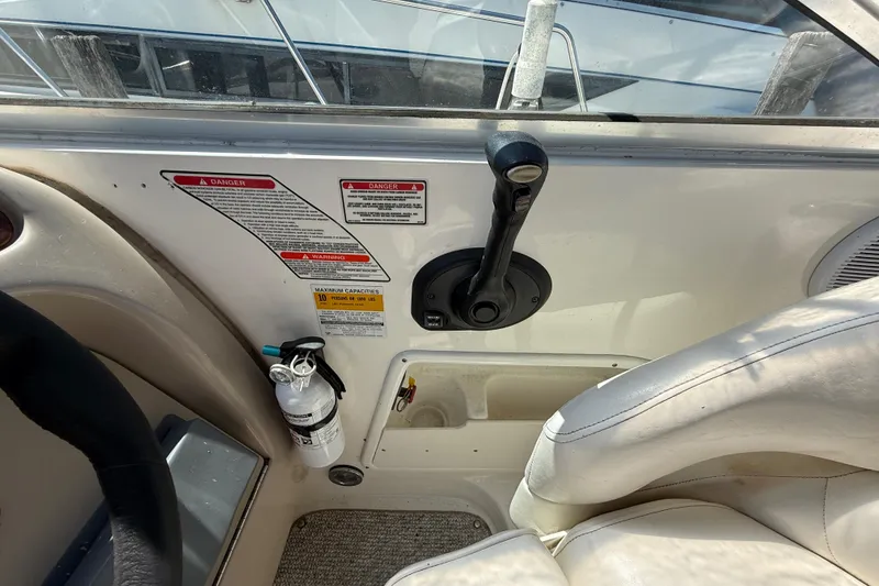 Slide: The Image of Control panel of a 2002 Sea Ray Sundancer 260 boat with safety labels and fire extinguisher. - 19