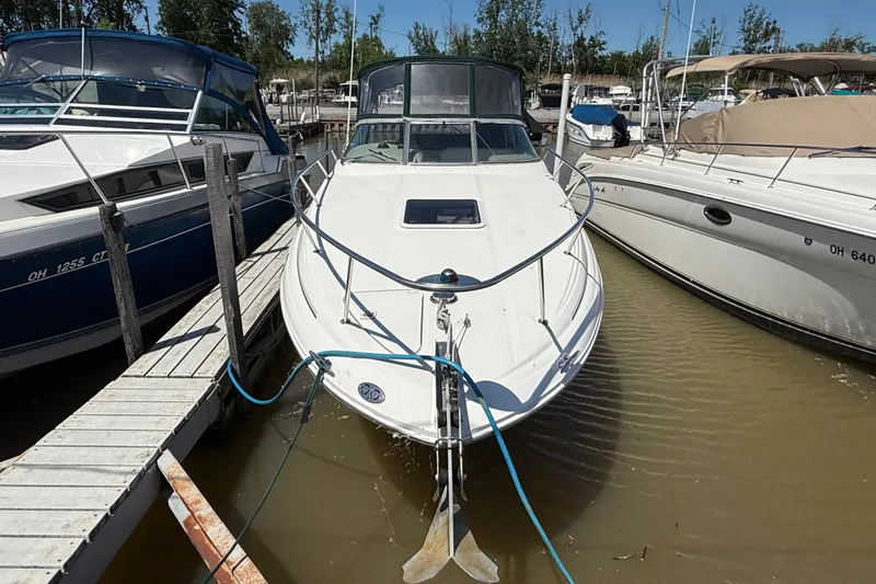 Slide: The Image of 2002 Sea Ray Sundancer 260 docked at marina, surrounded by other boats. - 2
