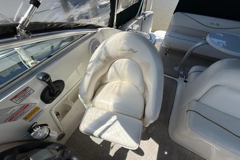 Slide: The Image of Interior of a 2002 Sea Ray Sundancer 260 boat with white seating and controls. - 20