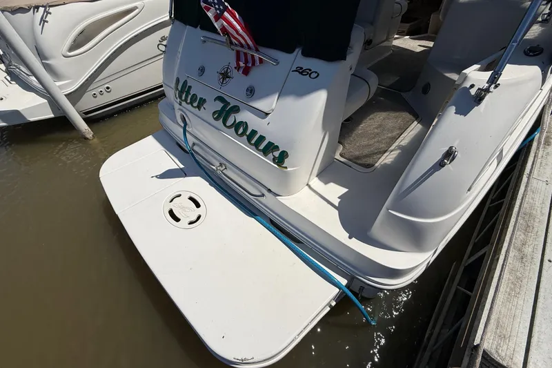 Slide: The Image of 2002 Sea Ray Sundancer 260 docked, featuring swim platform and American flag. - 3