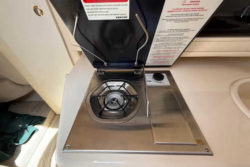 Slide: The Image of 2002 Sea Ray Sundancer 260 boat stove with single burner and safety instructions. - 30