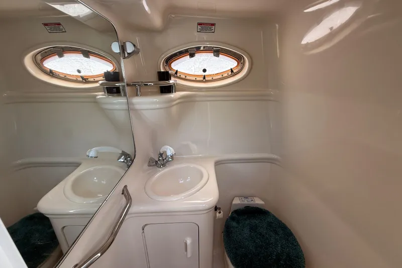 Slide: The Image of Interior of 2002 Sea Ray Sundancer 260 bathroom with sink, mirror, and porthole windows. - 32