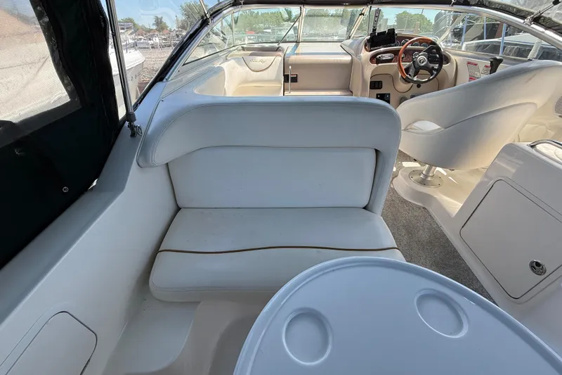 Slide: The Image of Interior of a 2002 Sea Ray Sundancer 260 boat, featuring white seating and helm area. - 7