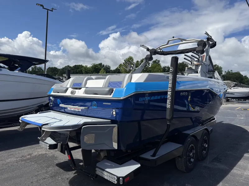 Slide: The Image of 2022 Malibu Wakesetter 25 LSV boat on trailer, blue hull, sunny day. - 3