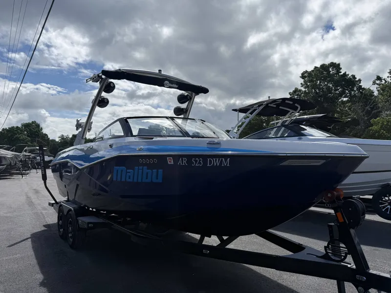 Slide: The Image of 2022 Malibu Wakesetter 25 LSV boat on trailer, blue hull, cloudy sky. - 5