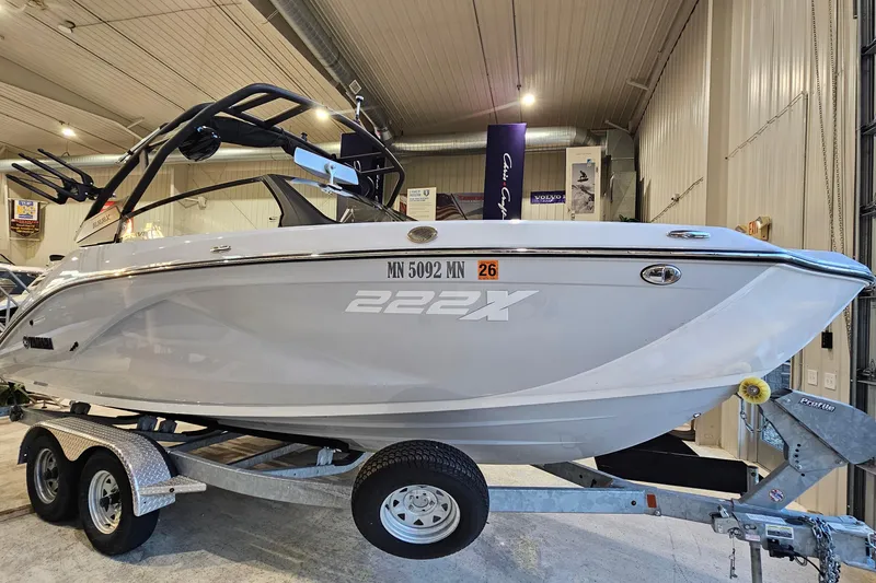 The Image of 2023 Yamaha Boats 222XD on trailer in indoor showroom setting. - 1