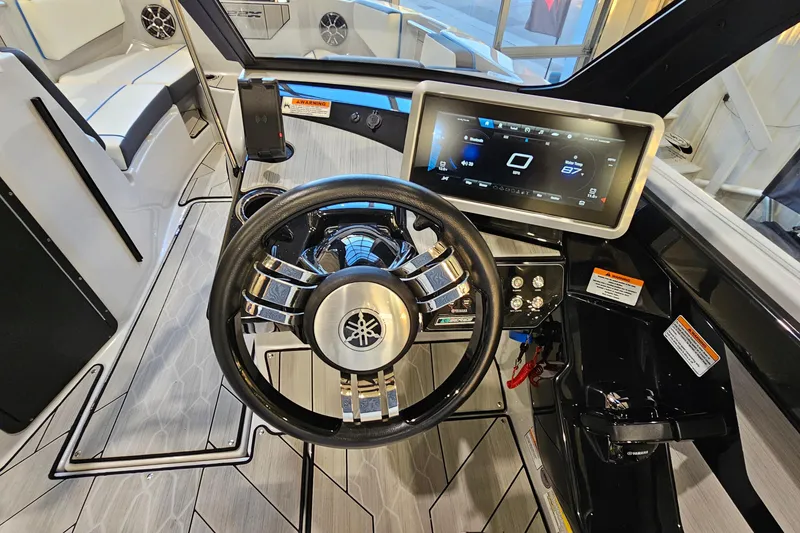 Slide: The Image of 2023 Yamaha Boats 222XD dashboard with steering wheel and touchscreen display. - 14