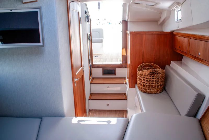 Slide: The Image of Interior of a 2027 MJM Yachts 38R with elegant wood furnishings and gray upholstery. - 34