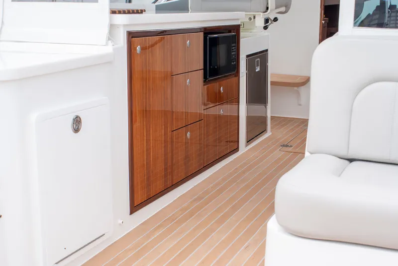 Slide: The Image of The interior of the 2027 MJM Yachts 38R features a sleek wooden galley with a microwave. - 13