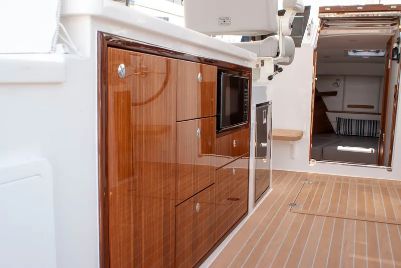 Slide: The Image of The 2027 MJM Yachts 38R features an elegant cabin with glossy wood cabinetry and modern amenities. - 15