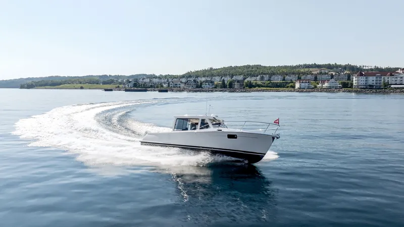 Slide: The Image of A 2027 MJM Yachts 38R speeds across calm water, with a shoreline in the background. - 1