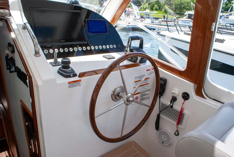 Slide: The Image of The cockpit of a 2027 MJM Yachts 38R with a sleek wooden steering wheel and modern instruments. - 30