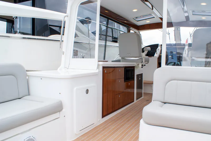 Slide: The Image of The image shows the cockpit of a 2027 MJM Yachts 38R with sleek seating and wood accents. - 10