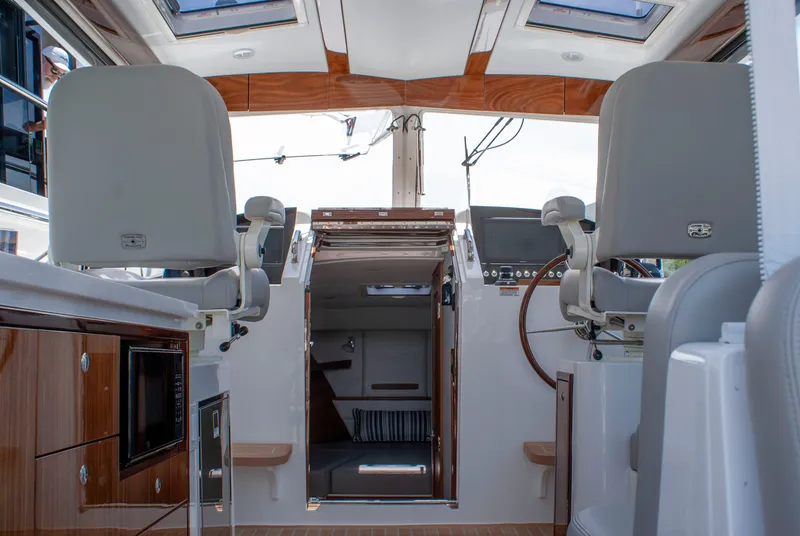 Slide: The Image of Interior view of a modern yacht with two helm seats and a wooden table. - 19