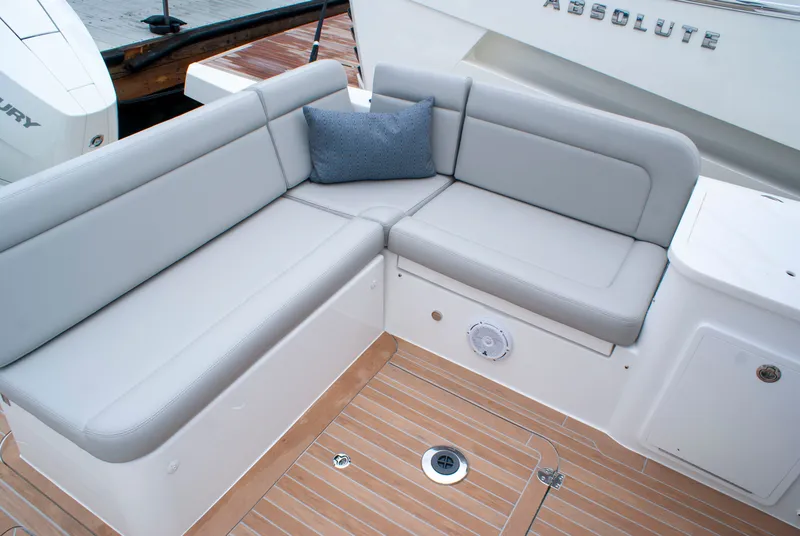 Slide: The Image of The 2027 MJM Yachts 38R features an elegant seating area with gray cushions and a blue pillow. - 7