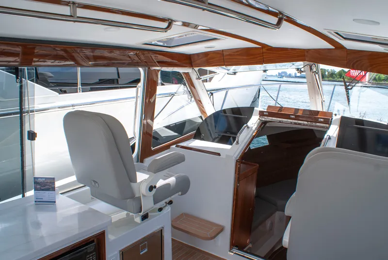 Slide: The Image of The image shows the cockpit of a 2027 MJM Yachts 38R with sleek seating and wood paneling. - 28