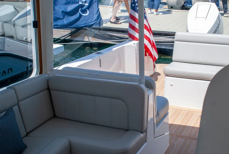 Slide: The Image of The image shows the cockpit of a 2027 MJM Yachts 38R with comfortable seating and an American flag. - 12