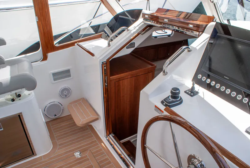 Slide: The Image of The image shows the cockpit of a 2027 MJM Yachts 38R with elegant wood finishes. - 27